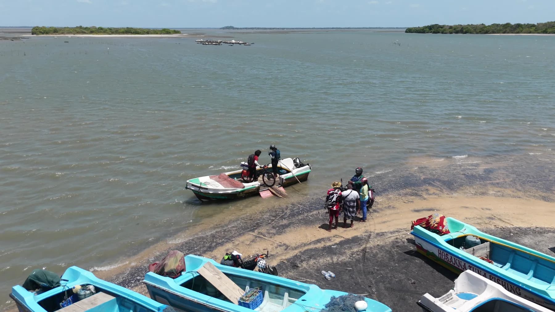 Intiaz and Subah loading their bicycles onto a small local boat at the Kokkilai crossing