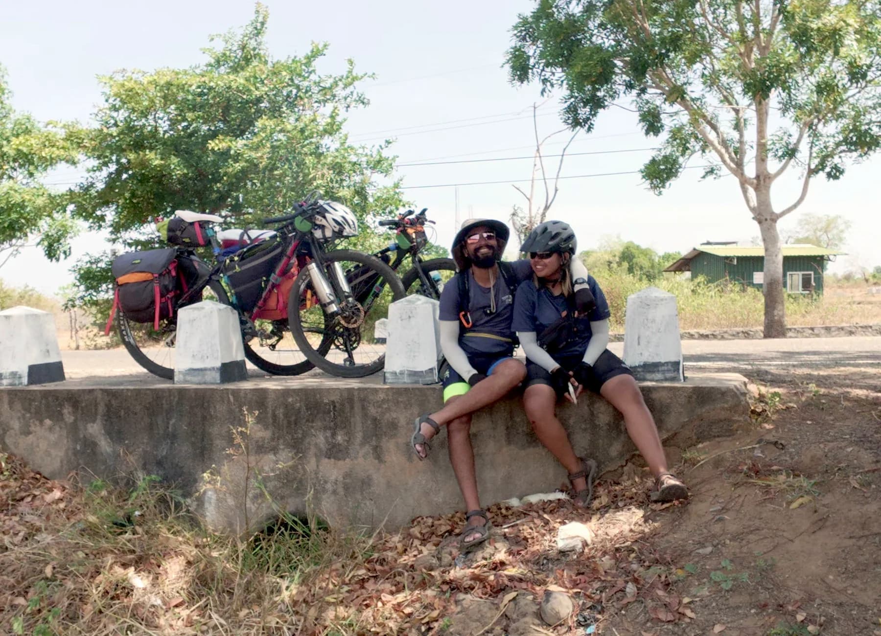 Intiaz and Subah sit together beside their loaded bicycles during a roadside pause in Sri Lanka