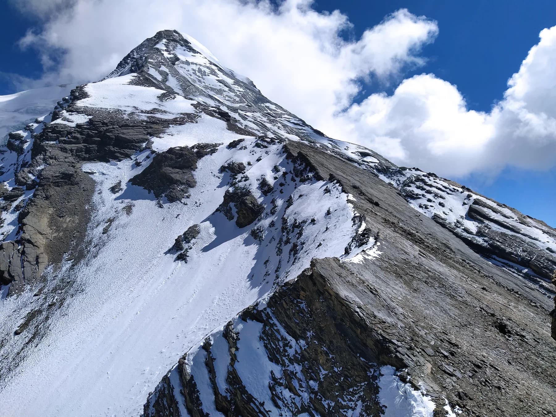 The steep rock-and-snow face of Pisang Peak under a blue Himalayan sky