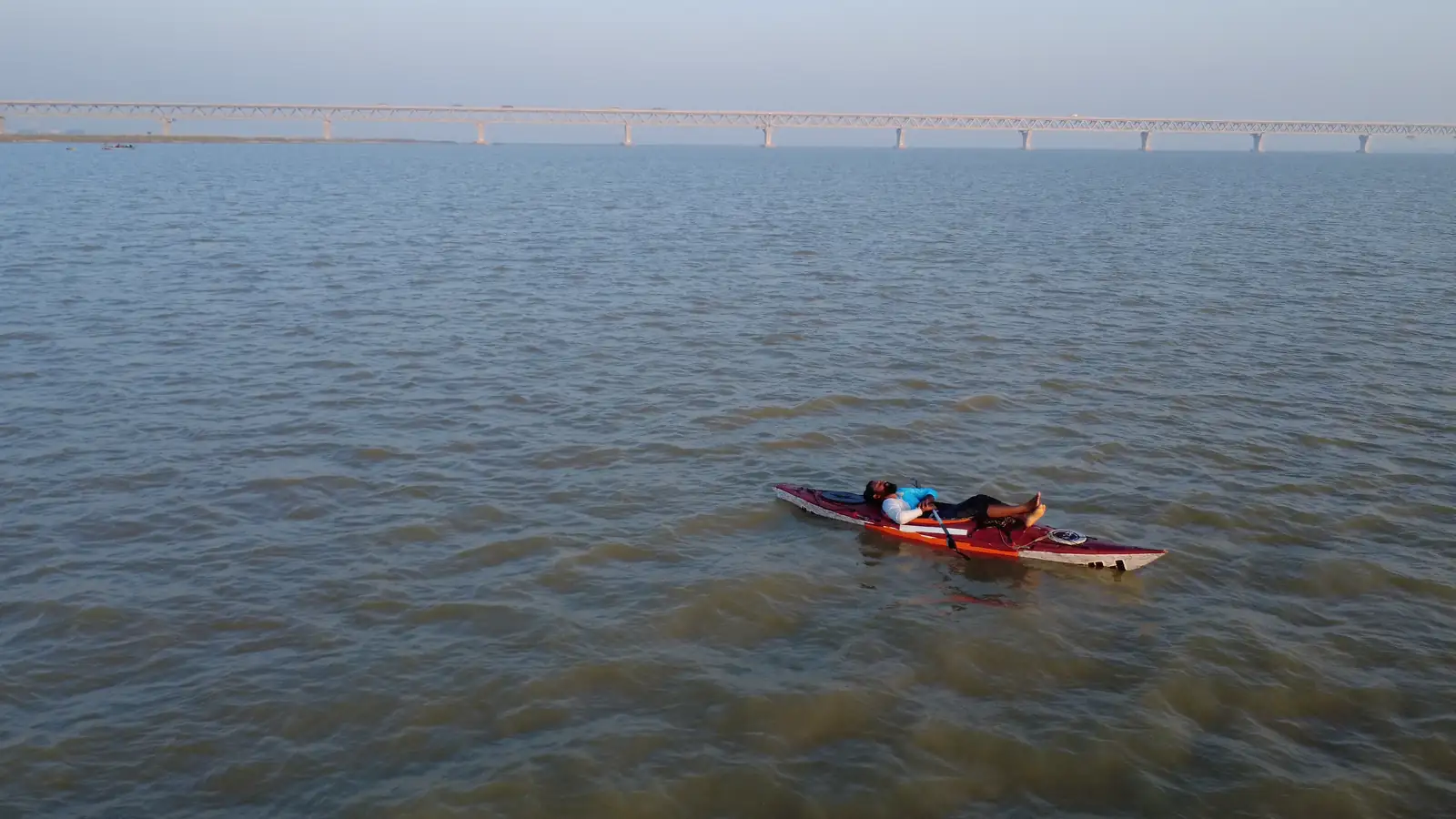 Intiaz Mahmud rests in his kayak on the Padma with Padma Bridge in the distance