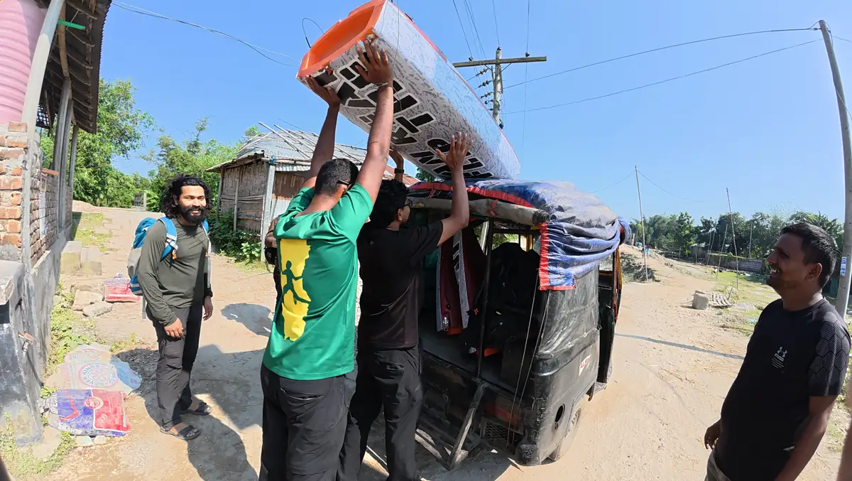 People lift the expedition kayak above an autorickshaw while Intiaz Mahmud stands beside it