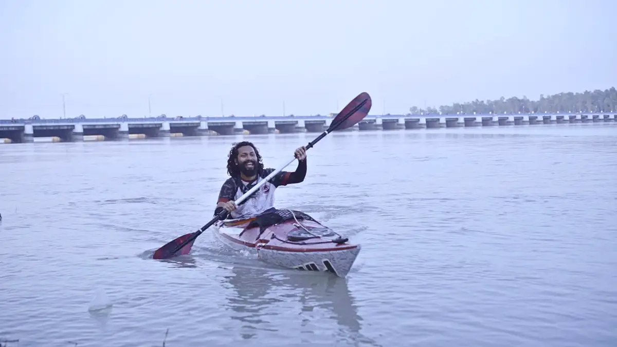Intiaz Mahmud paddles his kayak with Teesta Barrage behind him